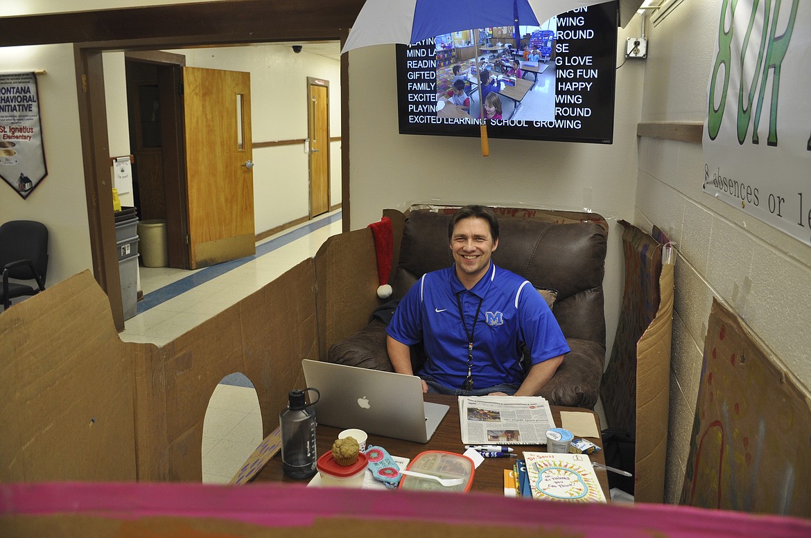 ST. IGNATIUS Elementary Principal Tyler Arlint sits in his cozy chair inside a box after students surpassed a February reading goal. (Ashley Fox/Lake County Leader)