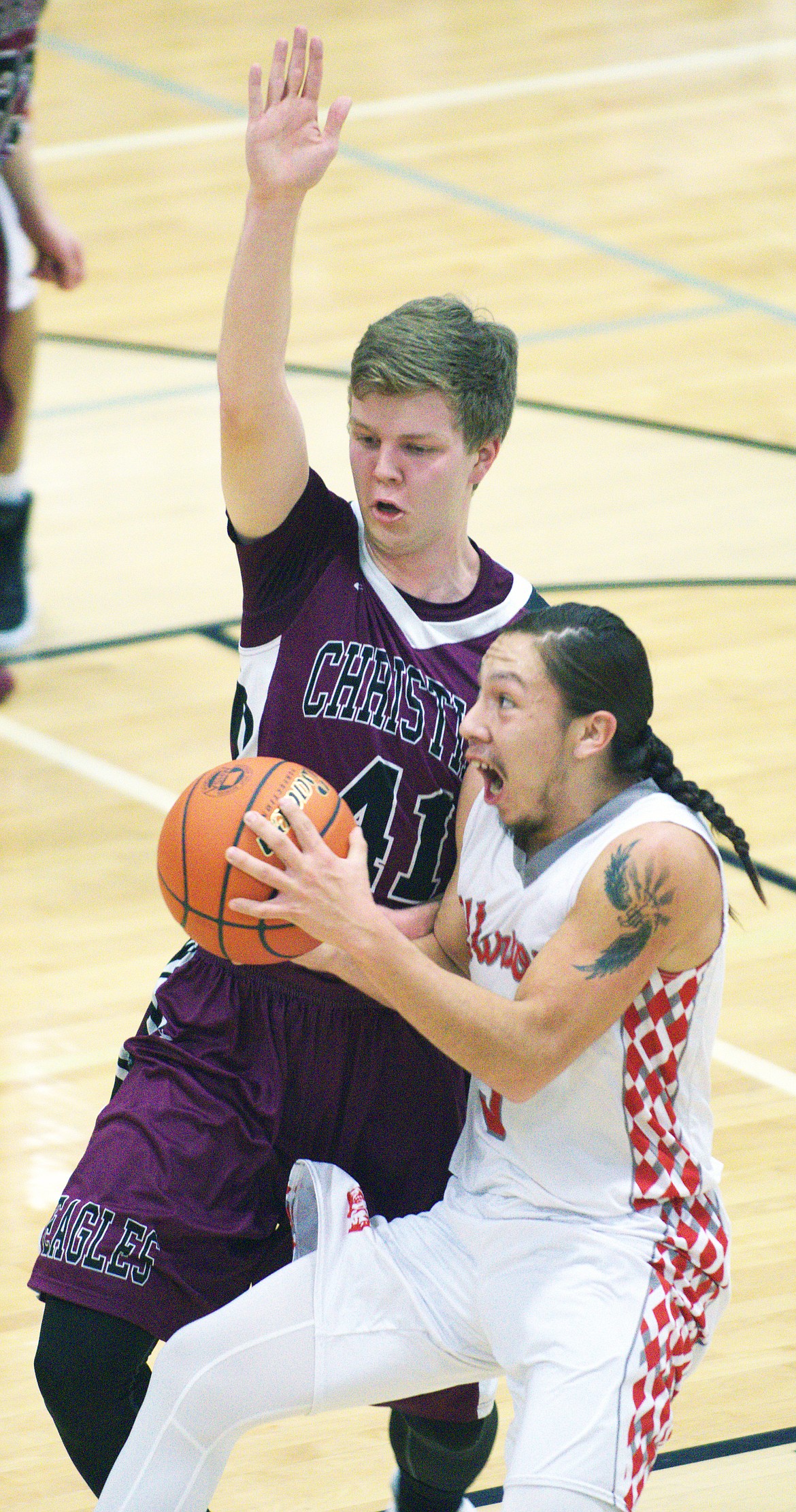 ARLEE GUARD Will Mesteth (3) drives to the basket against Manhattan Christian defender Josiah Amunrud (41) during the semfinal match of the MHSA Class C Western Divisional game Friday night at Hamilton. (Jason Blasco/Lake County Leader)