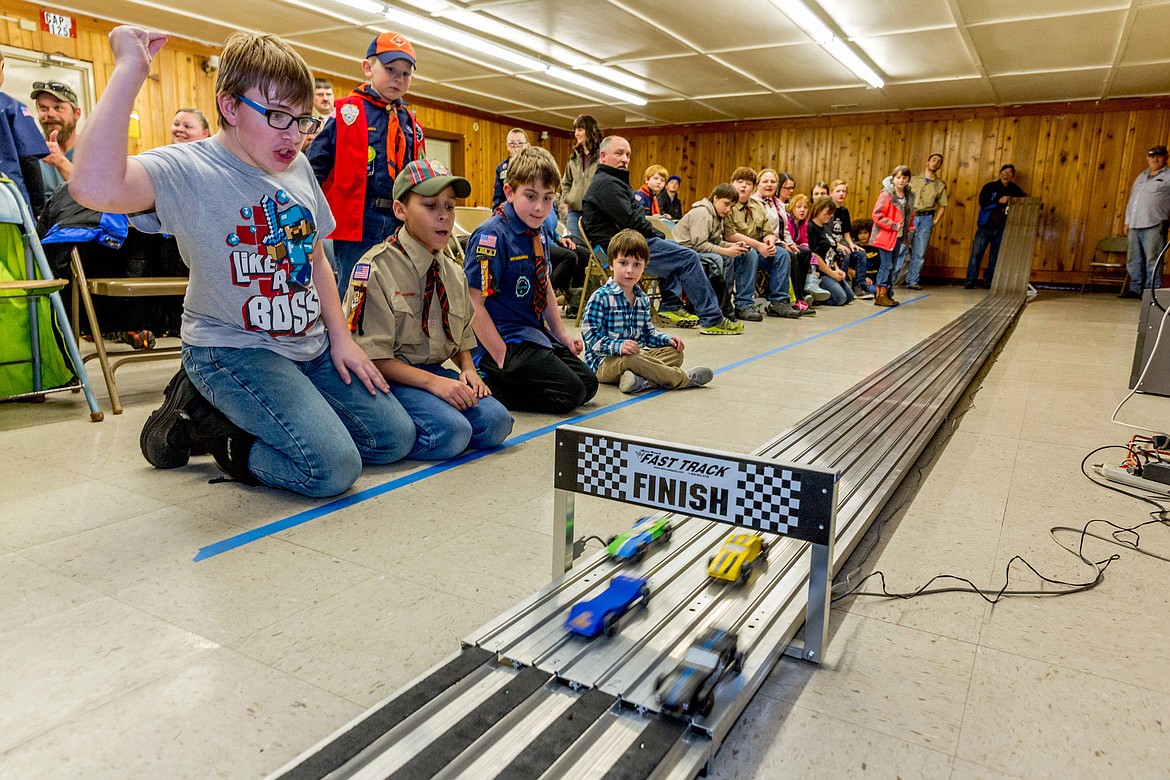 Sean Sanderson, left, Israel Prater, Elry Hall (standing) and Aaron Thomas cheer on their cars as Landon Wheeler looks on Friday, March 2, 2018. (John Blodgett/The Western News)