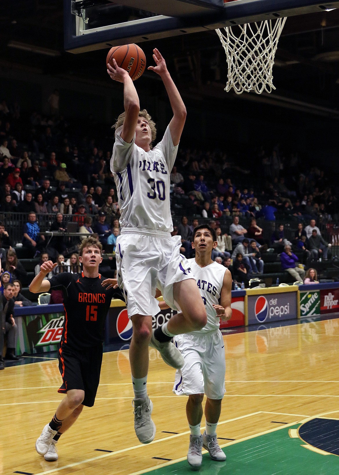 POLSON PIRATES guard Conner Lanier (30) blows past Frenchtown defenders to try to take the ball to the basket in the opening round of the Class A Western Divisionals at the Butte Civic Center. (photo courtesy of Bob Gunderson)