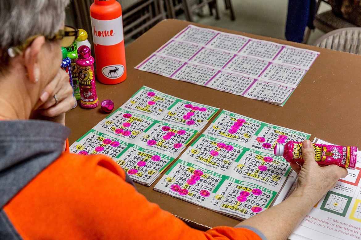 Jeanne Butler surveys her bingo cards at Libby Senior Center on Saturday, March 3, 2018. (John Blodgett/The Western News)