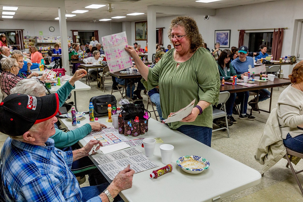 Cindy Wagner gathers used bingo cards at Libby Senior Center on Saturday, March 3, 2018. (John Blodgett/The Western News)