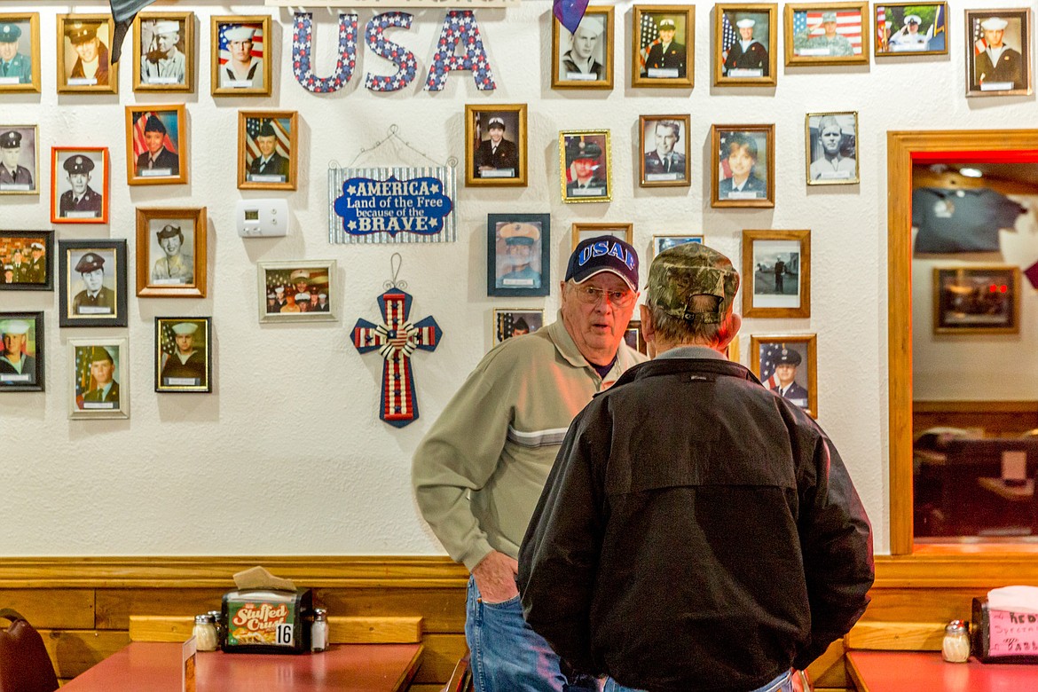 Clarence Watson, left, and John Dickens reminisce in front of the &#147;Wall of Honor&#148; at Simple Simon&#146;s Pizza Feb. 9. (John Blodgett/The Western News)