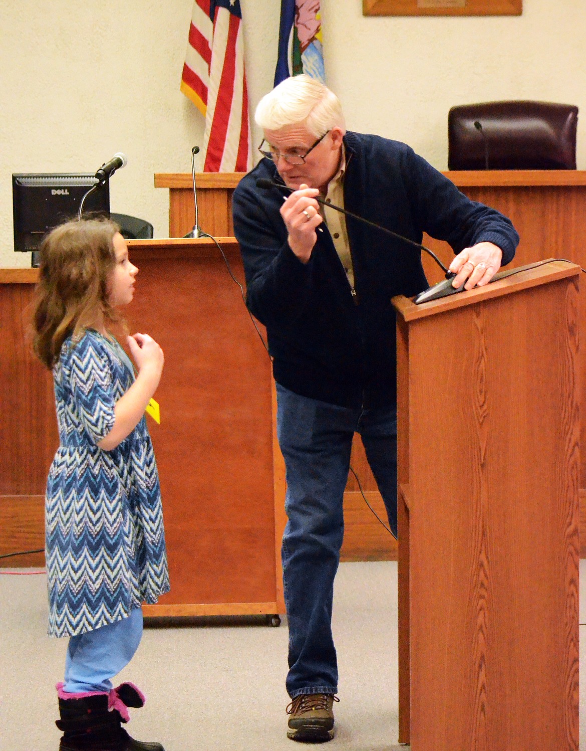 Young Sabrina McGaughey of Thompson Falls gets some help from Dan Whittenburg as he adjust the microphone for her. (Erin Jusseaume/ Clark Fork Valley Press)