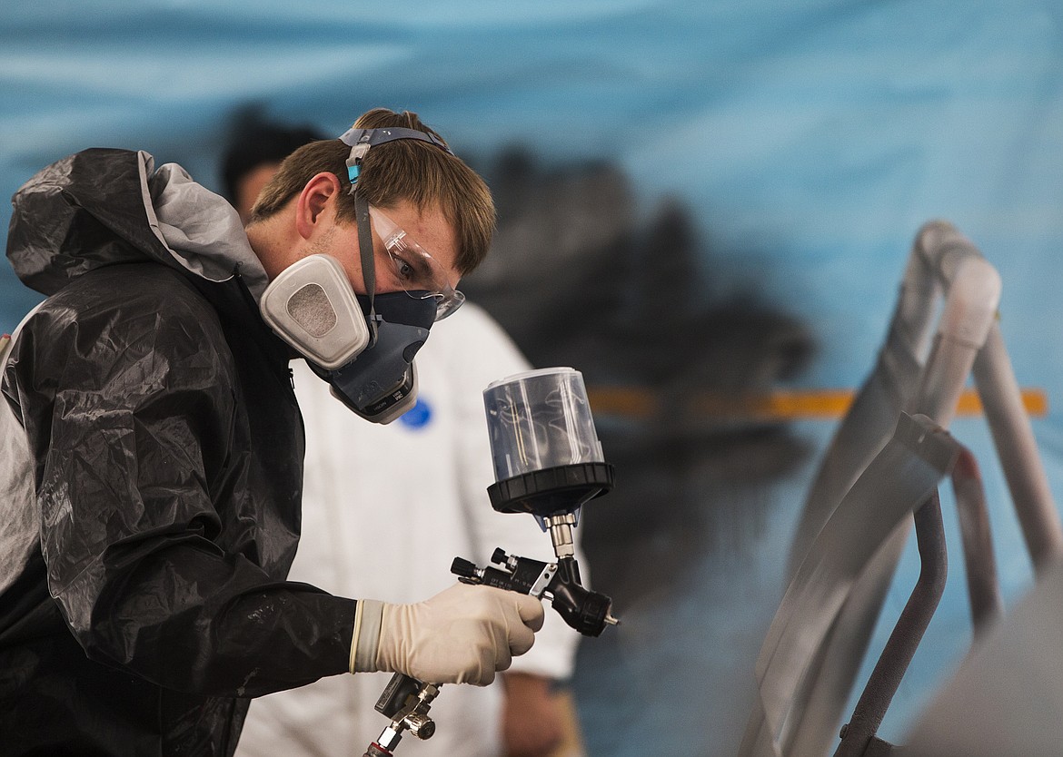 Murray Sauer applies paint finish to a car panel during a Skills USA Collision Scrimmage competition Friday morning at North Idaho College Parker Technical Education Center.  (LOREN BENOIT/Press)
