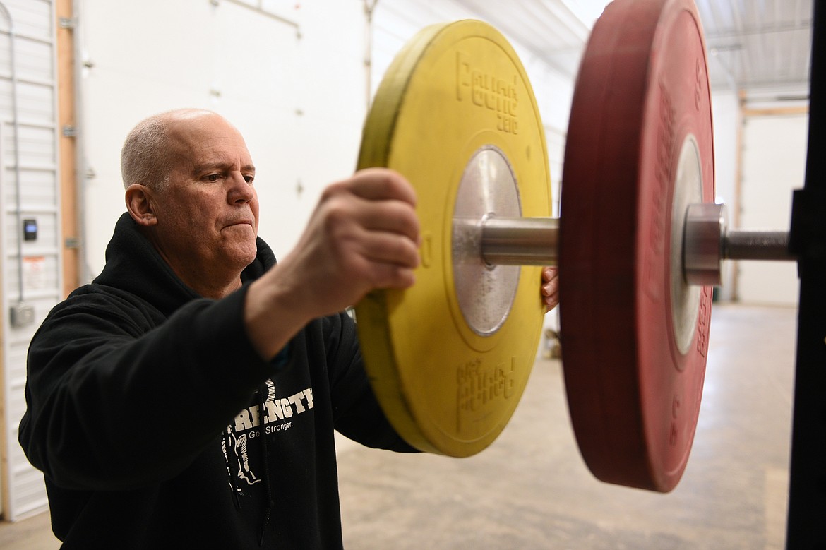 Mike Gerber, owner of Montana Sport-Strength, adds weight to the bar while Henry Nuce, a sophomore at Glacier High School, works out on Tuesday, Feb. 20. (Casey Kreider/Daily Inter Lake)