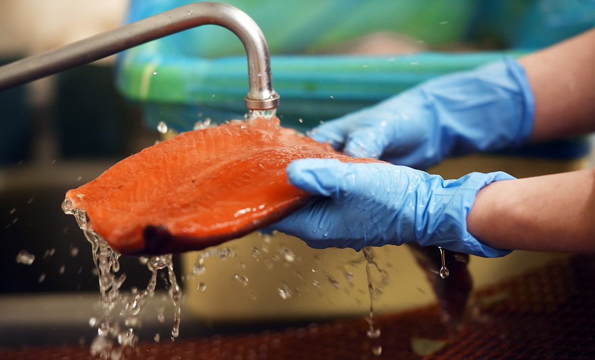 Amanda Wlaysewski rinses a salmon fillet before seasoning it.