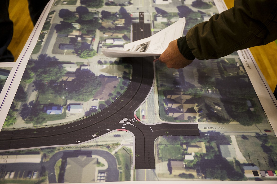 Berl Dougall points to his home on a display table as he speaks about his property concerns to HMH engineer Marcus Levesey during a hearing for improvements to the intersection at U.S. 95, Lincoln Way and Walnut Avenue. (LOREN BENOIT/Press)