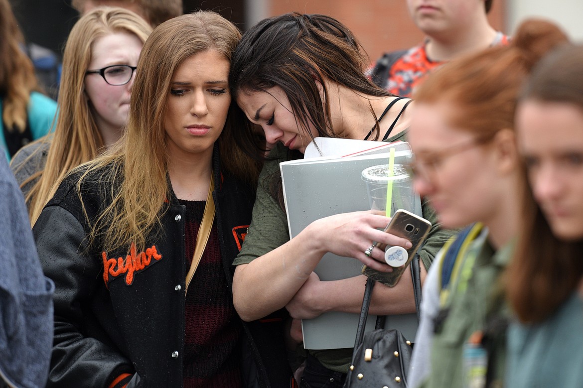 Flathead High School seniors Skylar Collins, left, and Lexi Ren participate in the student-planned &#147;17 Minutes of Silence Memorial&#148; Wednesday afternoon to mark one month since a mass shooting left 17 dead at Marjory Stoneman Douglas High School in Parkland, Florida. (Casey Kreider/Daily Inter Lake)