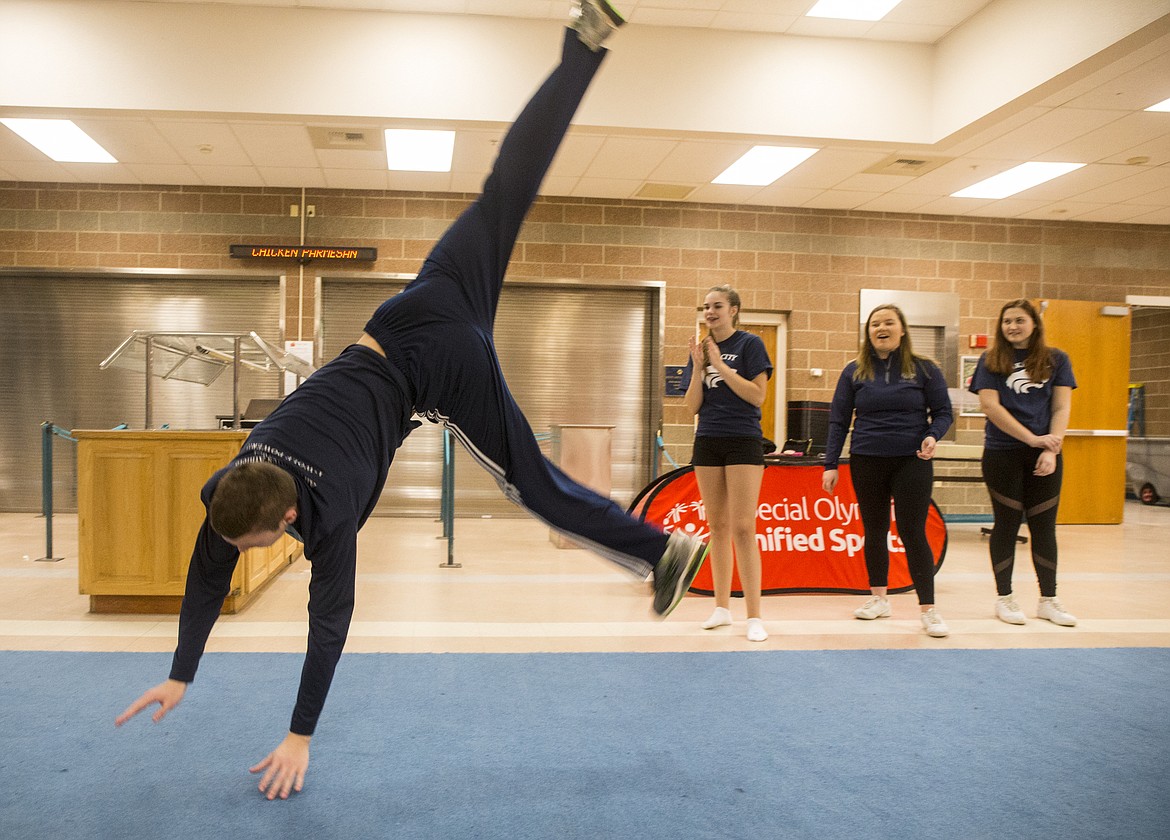 Volunteer cheer coaches, Jessica Gilmore, Shelby Beaton, Maddianna Morrow cheer for Jake Ragsdale as he practices a cartwheel Thursday evening at an All Abilities cheer practice at Lake City High School. (LOREN BENOIT/Press)