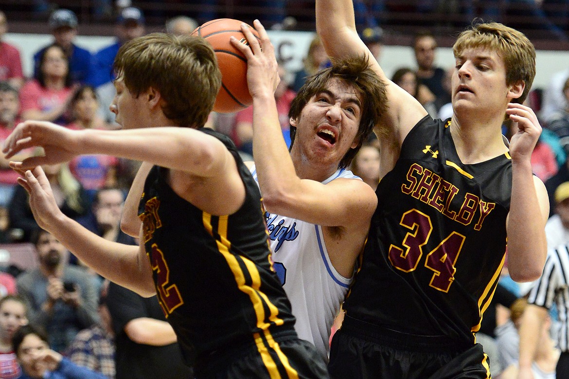 Bigfork's Beau Santistevan drives to the basket between Shelby defenders  Aaron White, left, and Macager McAllister during a 60-56 win in the championship of the 2018 State Class B Boys' Basketball Tournament at Dahlberg Arena in Missoula on Saturday, March 10. (Casey Kreider/Daily Inter Lake)