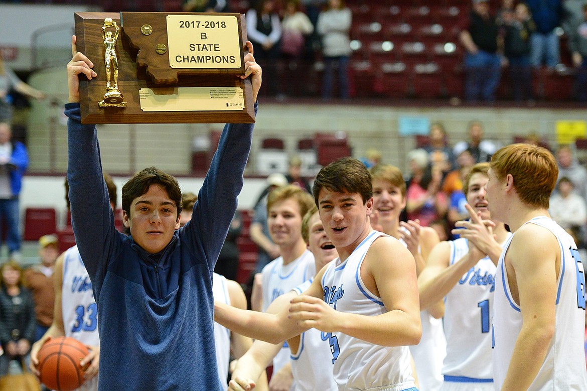 Bigfork team manager Logan McMann holds the state championship trophy after a 60-56 win over Shelby at Dahlberg Arena in Missoula on Saturday, March 10. (Casey Kreider/Daily Inter Lake)