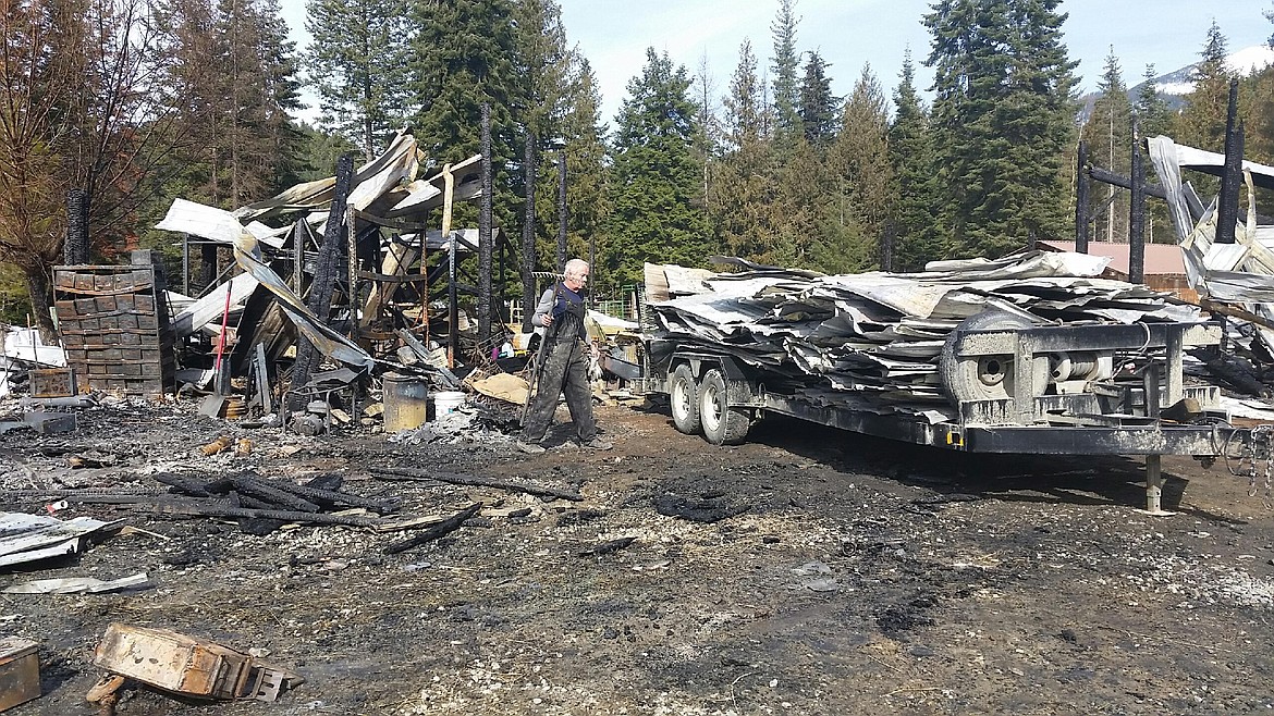 Courtesy Photo
Larry Humberg loads burned metal roofing on the trailer loaned to them by Bill Mutter.