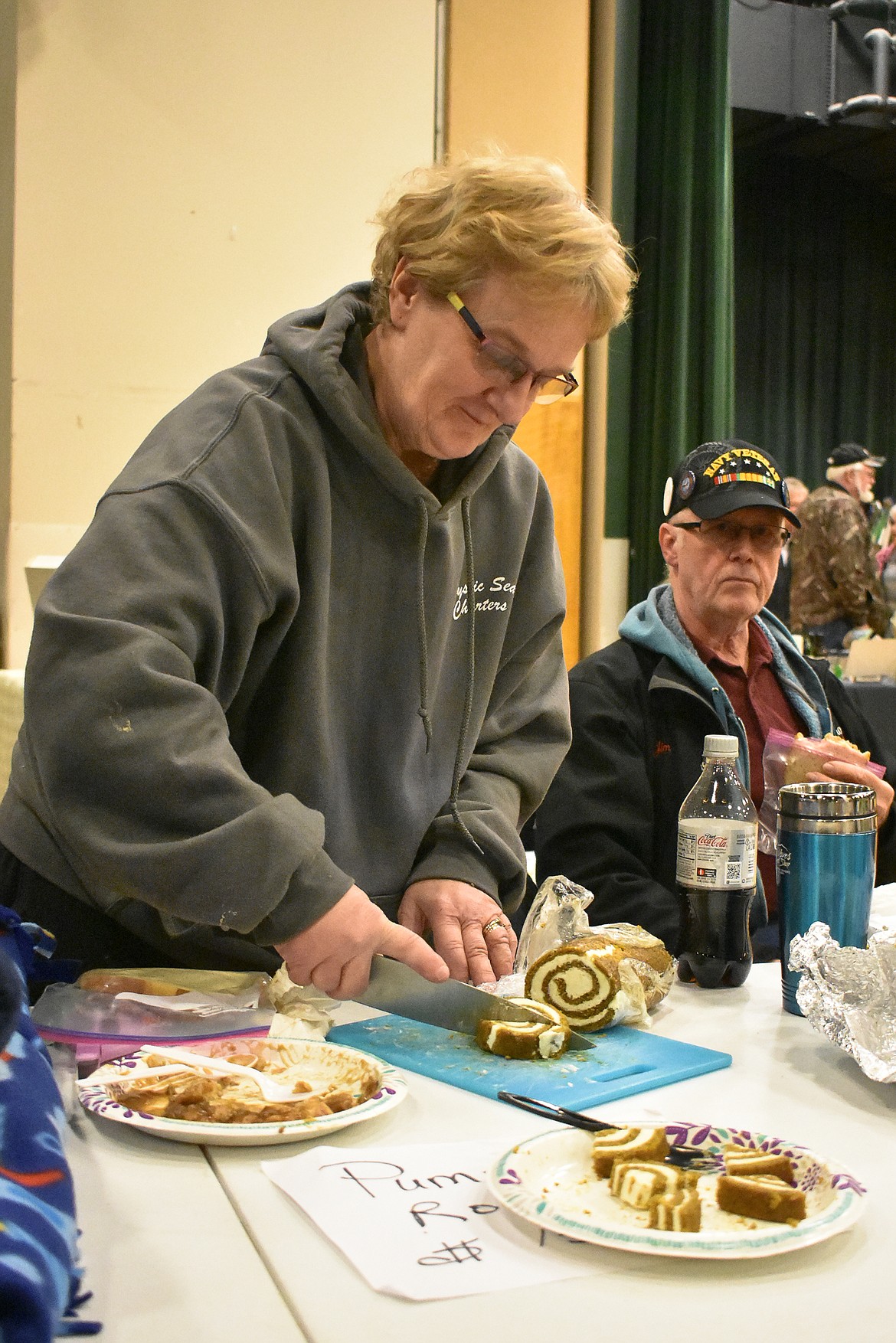 Cheryl Wegner cuts pieces of pumpkin roll as her husband James observes during the 23rd annual Libby Irish Fair March 10. A first-time vendor, Wegner said she isn&#146;t used to live music at events where they vend, and that she enjoyed it. (Ben Kibbey/The Western News)