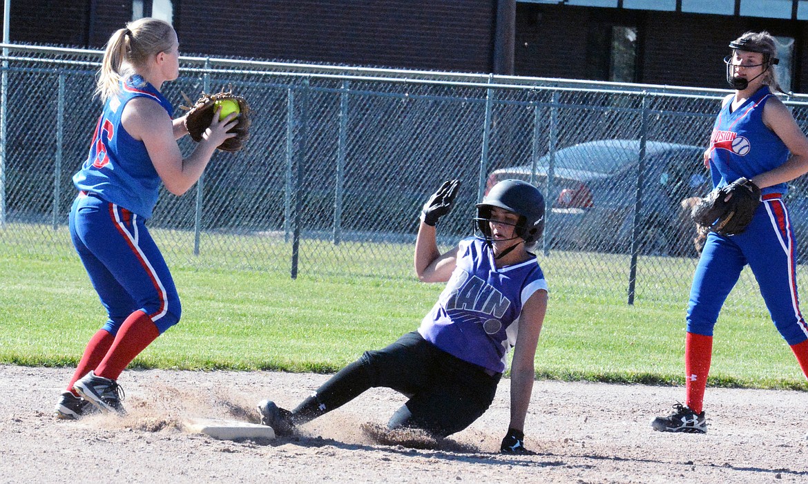 POLSON HIGH School player Paige Noyes (middle) slides into second base during a summer softball tournament. (Photo by Jason Blasco/Lake County Leader)