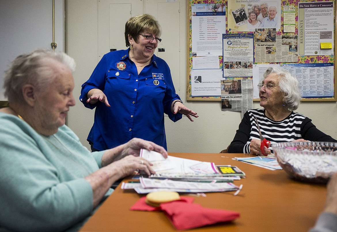 Beverly Hanson, center, with Veterans of Foreign War Auxiliary 889 chats with Corinne MacDonald, right, as she cuts coupons to send to military families overseas Tuesday morning at Legends Park Assisted Living in Coeur d'Alene. (LOREN BENOIT/Press)