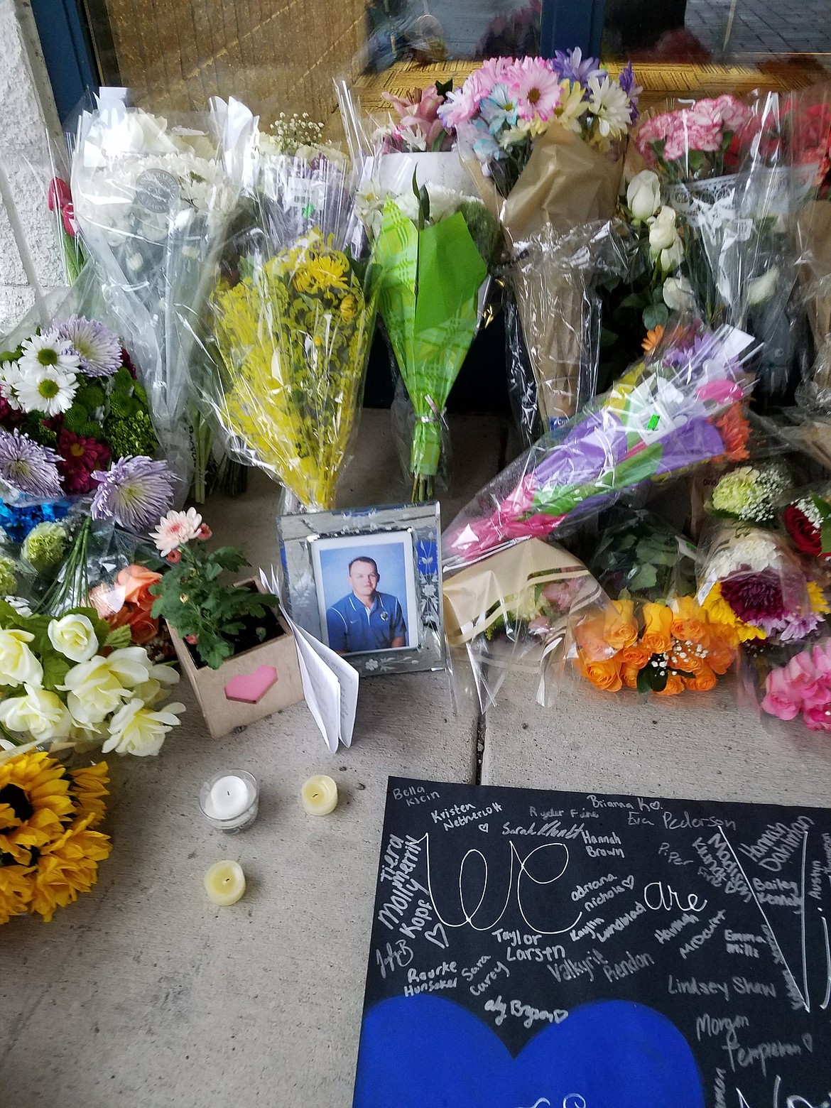 Courtesy photo
Flowers and candles are seen at the entrance to Coeur d&#146;Alene High School in remembrance of principal Troy Schueller.