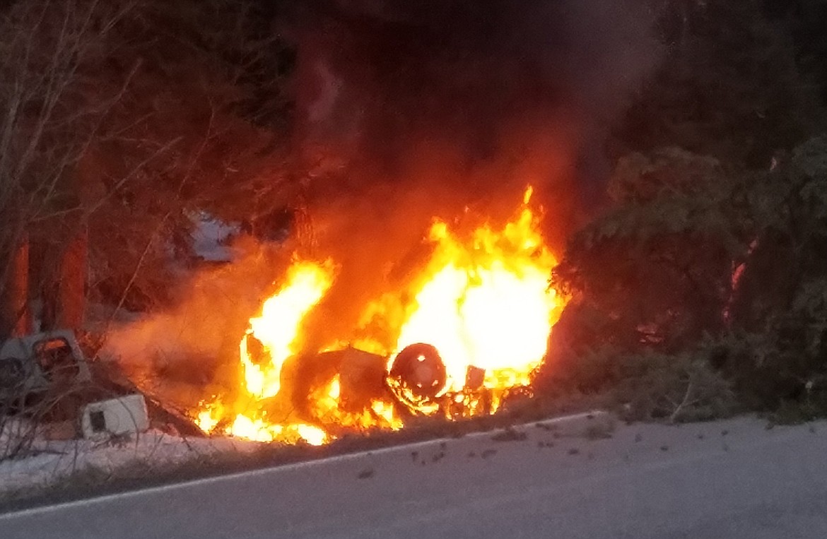 A pickup bursts into flames on March 20 after hitting a tree on Montana 83 in Lake County. This photo was taken after the man was pulled from the vehicle by four passers-by. (Photo provided)