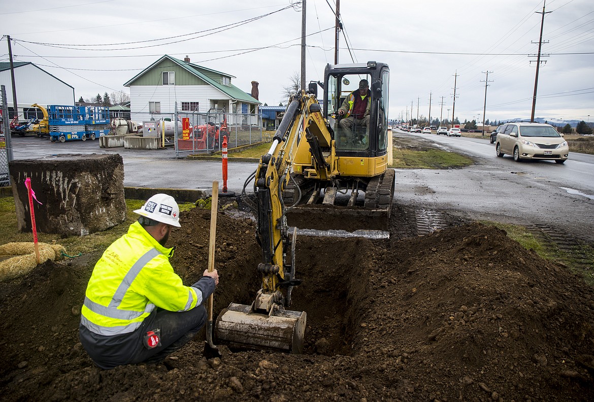 Russel Seymour, left, and Gary Degroot with LaRiviere Construction work to replace the waterline North of Canfield Avenue and Government Way Thursday as part of the $4.5 million road widening project between Hanley and Prairie avenues. (LOREN BENOIT/Press)