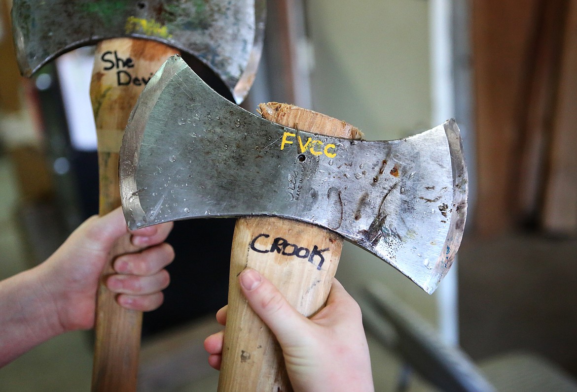 Katie Haas holds a pair of axes during logger sports practice at Flathead Valley Community College.