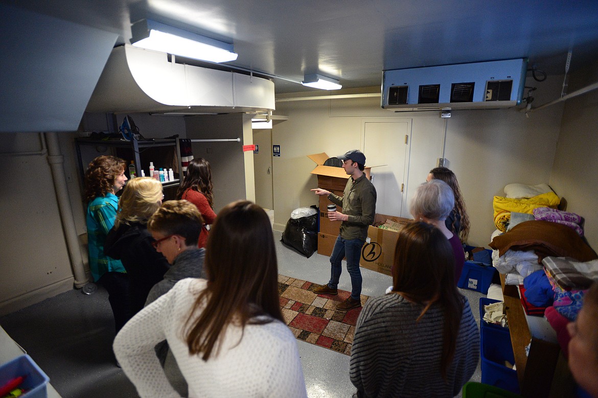 Adam Sommers, with AmeriCorps VISTA, shows volunteers a basement area with bathrooms and hygiene items for students in low-income families at the HEART Locker in Kalispell.