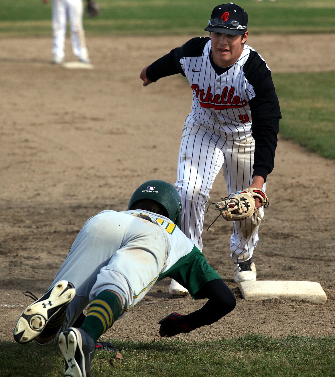 Rodney Harwood/Columbia Basin Herald
Othello third baseman Joshua Garza (9) tags out Quincy runner Conner Donovan (20) after Donovan over-ran the bag trying to move into scoring position on Saturday during CWAC baseball action at Quincy.