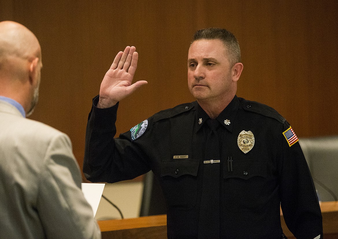 LOREN BENOIT/Press 
Post Falls Mayor Ron Jacobson, left, affirms Pat Knight&#146;s oath to become Post Falls Police Chief Pat Knight Tuesday at Post Falls City Hall. Knight&#146;s first day will be April 1.