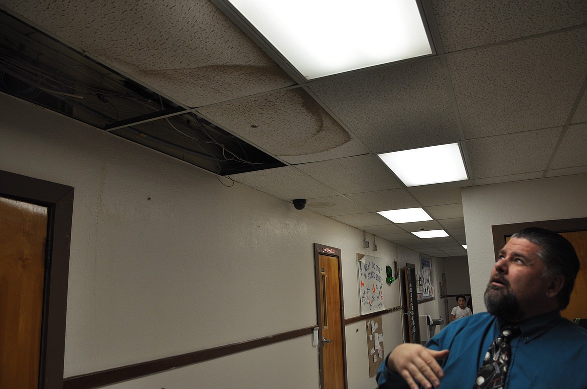 St. Ignatius Superintendent Jason Sargent looks up at a leaky roof at St. Ignatius Elementary. The roof is slated to be fixed this summer. (Ashley Fox/Lake County Leader)