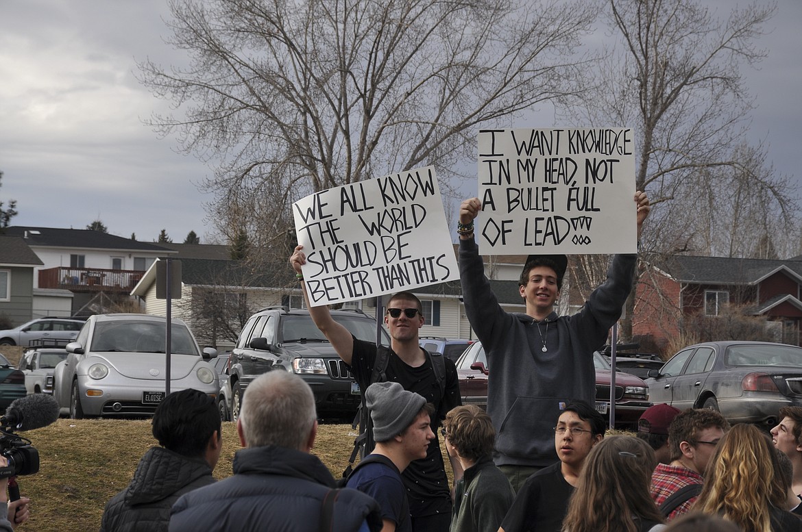 RUSSELL SMITH, a senior, left, and junior Michael Vergeront hold signs during a walk-out protest at Polson High School. (Ashley Fox/Lake County Leader)