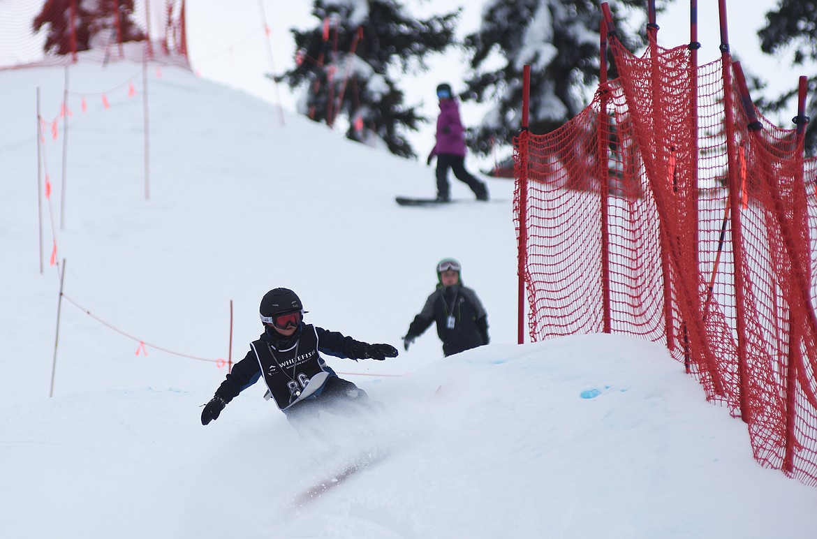 A young snowboarder kicks up some powder during the Nate Chute Banked Slalom and Boardercross competition last weekend at Whitefish Mountain Resort. (Daniel McKay photos/Whitefish Pilot)