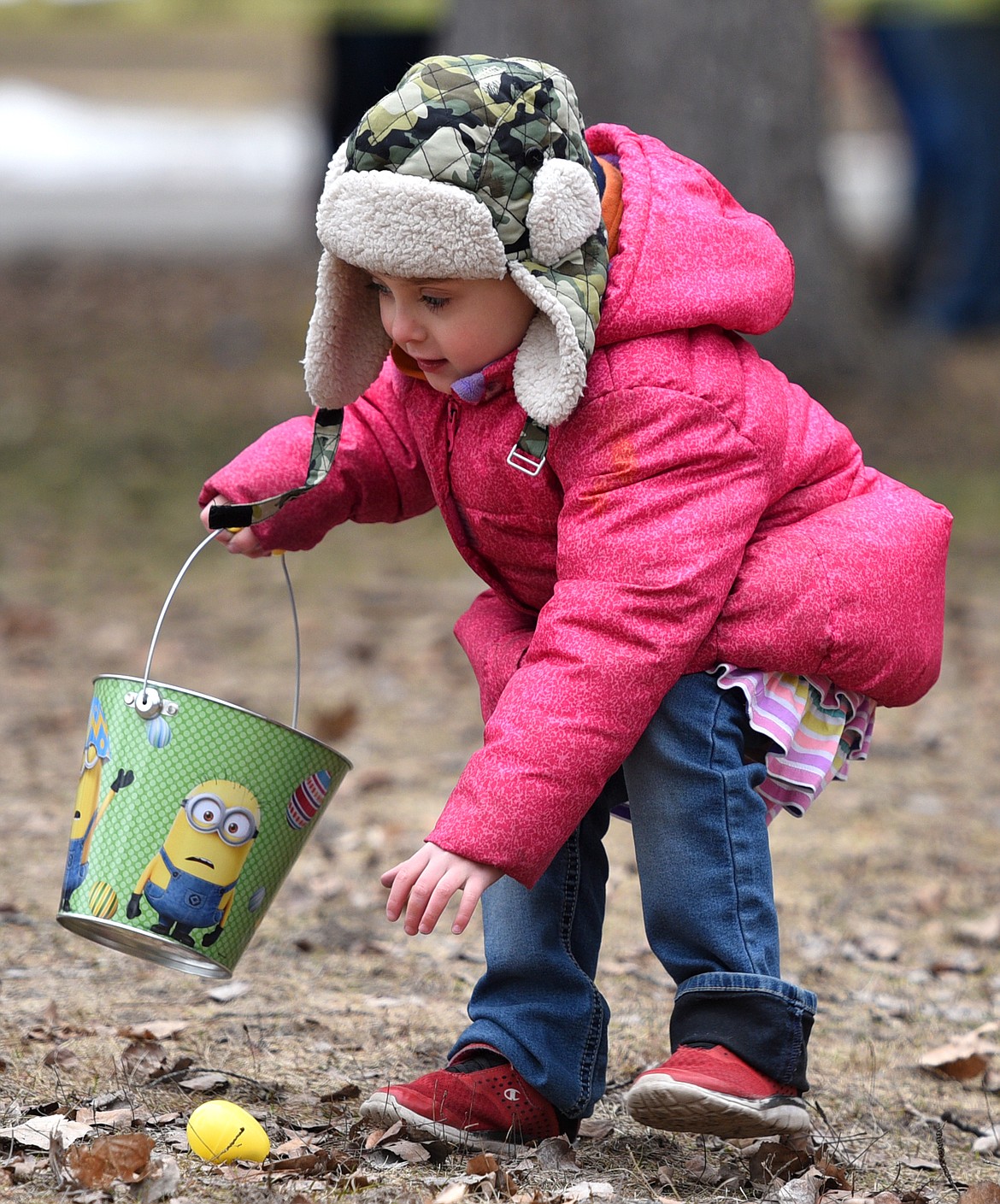 A young girl picks up an egg during the 6th annual Flathead Shelter Friends Easter Egg Hunt at Woodland Park on Saturday in Kalispell. (Casey Kreider/Daily Inter Lake)