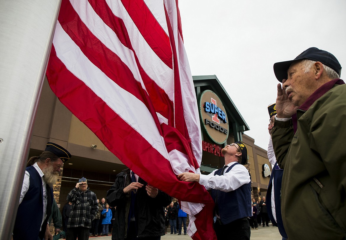 Photos by LOREN BENOIT/Press
Members of the American Legion Post 149 raise the American flag in front of the new Super 1 Foods store at The Crossings Tuesday evening in Athol. The store was under construction since July and will be open today at 7 a.m.