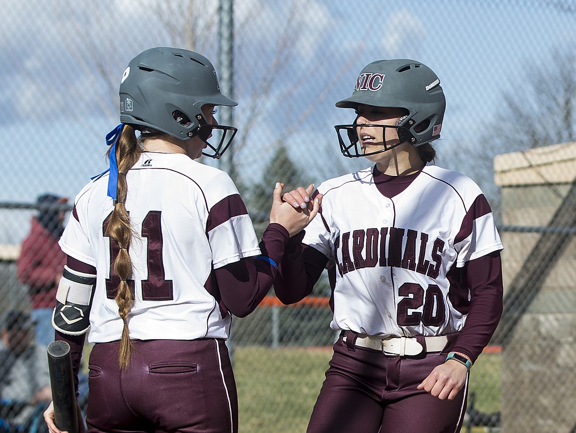 Megan Carver, left, greets Kayla Curtan of North Idaho College as she crosses home plate against Treasure Valley.
