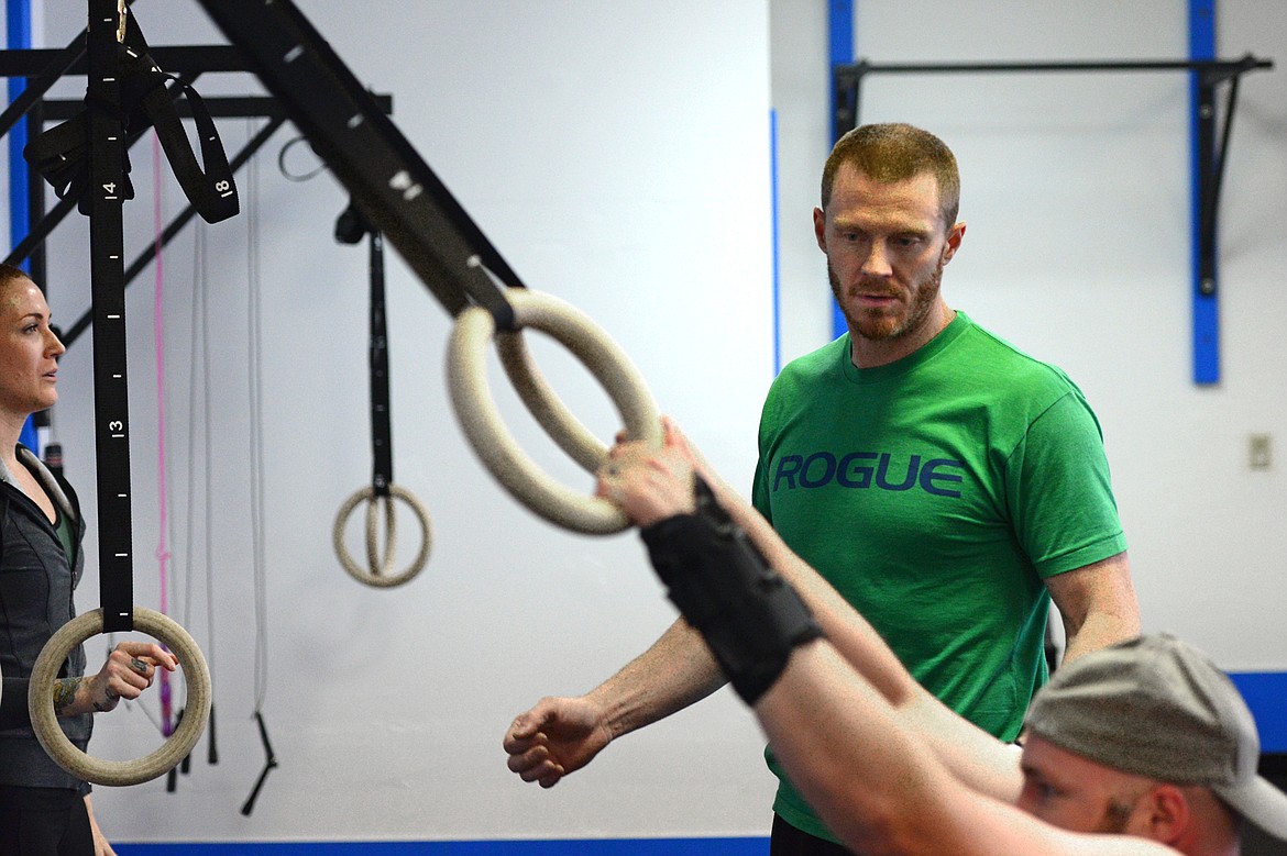 Bigfork Crossfit owner Isaac Lee watches a workout with members Nikkie Armstrong, left, and Cole Armstrong.