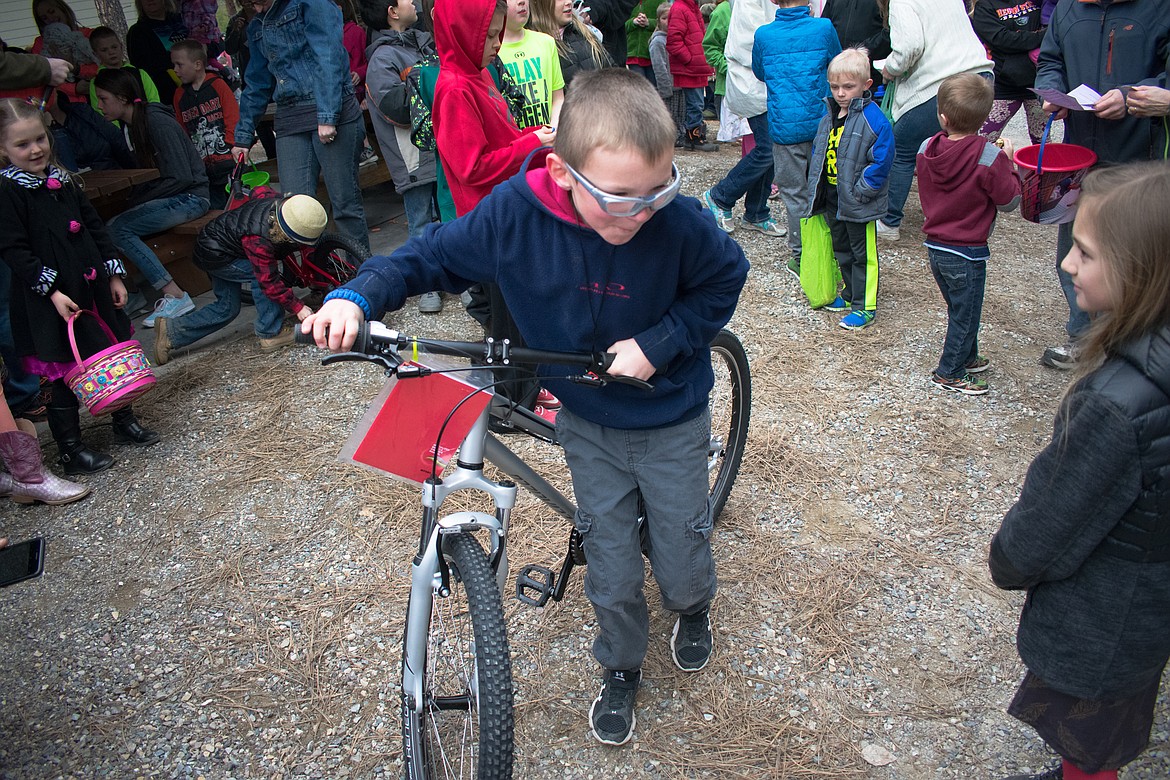 Nine year old Kale Hall heads off with his bike and a smile as one of the raffle winners at Libby Christian Church, March 31. (Ben Kibbey/The Western News)