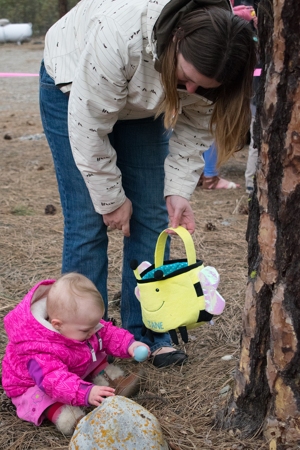 One year old Jane Grossman lost her balance while gathering Easter eggs at Libby Christian Church, but kept going with the help of her mother Cassie, March 31. (Ben Kibbey/The Western News)