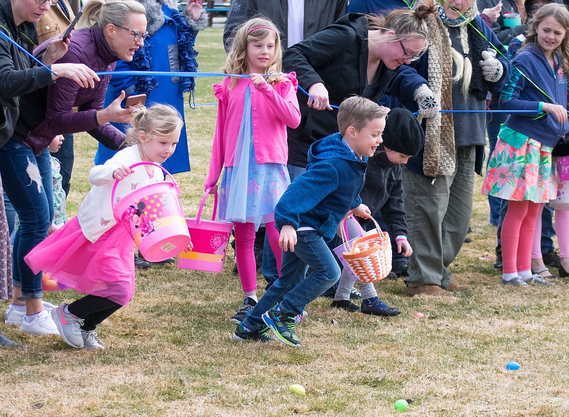 Ariah and Oz Pennock tear off at the start of the Easter egg hunt for ages three to four at Roosevelt Park in Troy. (Ben Kibbey/The Western News)