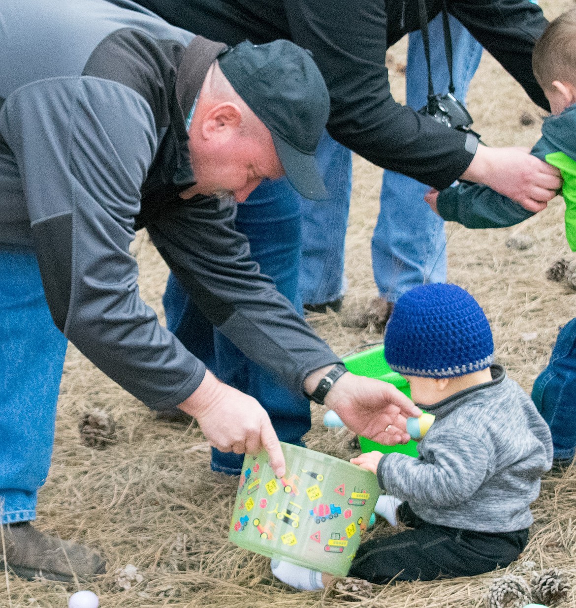 Rocky Bothman helps his grandson, 11 month old Brooks Grotjohn, with the concept of Easter eggs at the Libby Christian Church March 31. (Ben Kibbey/The Western News)