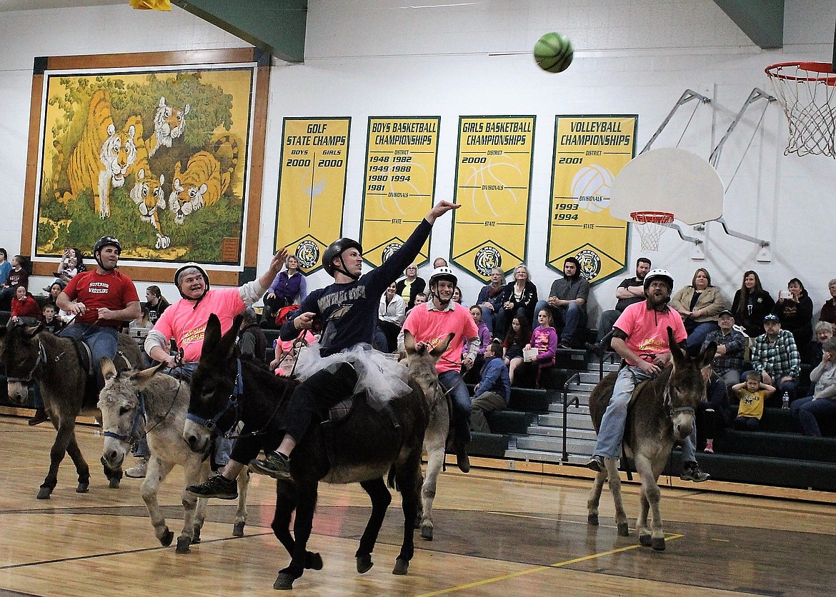 Superior teacher Beaut Servo shoots for two during a donkey basketball game against St. Regis staff despite a great block by Sarge in Charge, Joe Steele. Superior staff won the championship game, 8 to 4.