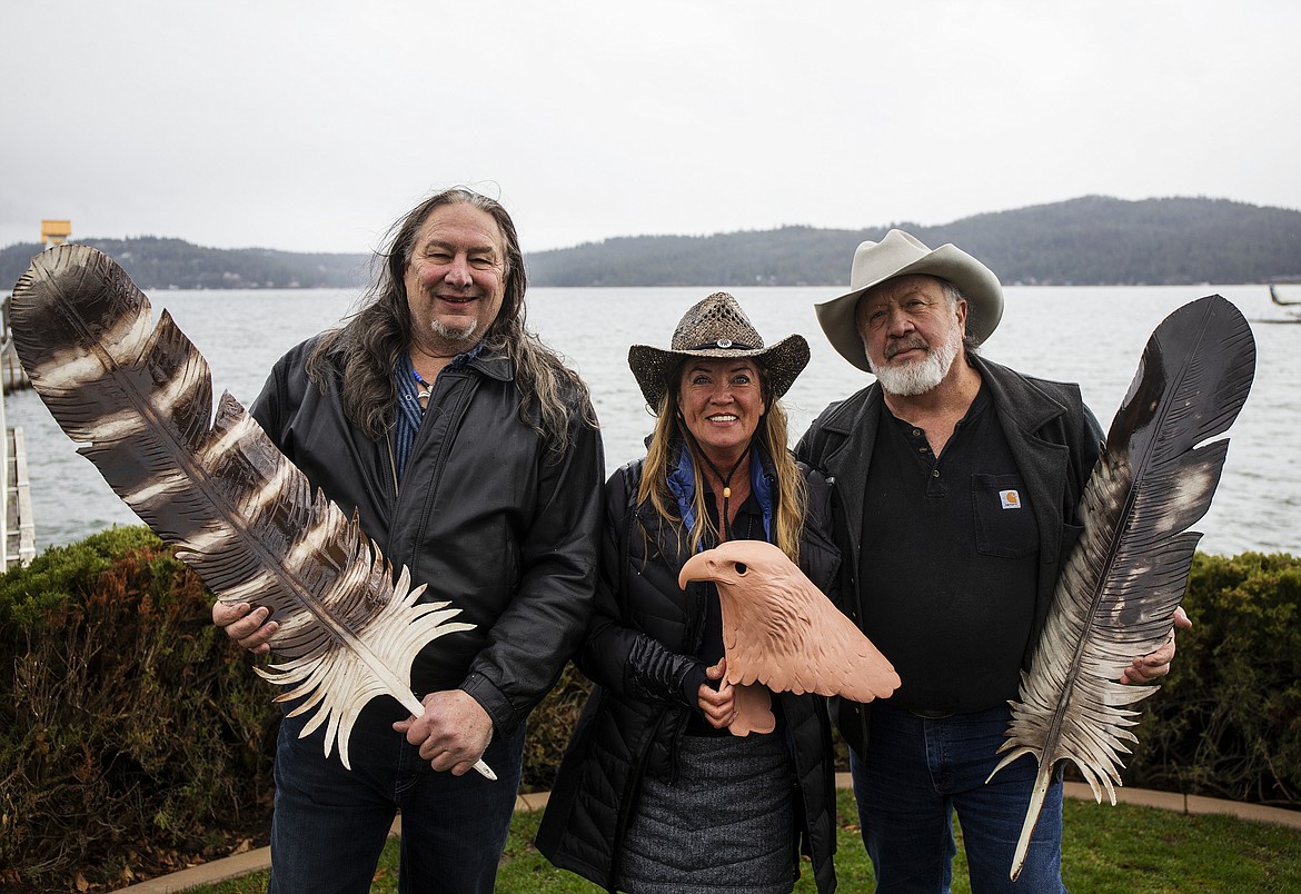 LOREN BENOIT/Press
Artist David Govedare, left, Birds of Prey Northwest President Janie Veltcamp, center, and artist Keith Powell hold artwork that will be auctioned off during Birds of Prey Northwest&#146;s &#147;Fly Like an Eagle&#148; program on Friday at The Coeur d&#146;Alene Resort. The feathers are modeled after the public art feathers that can be seen as residents and visitors drive into downtown Coeur d&#146;Alene along Northwest Boulevard.
