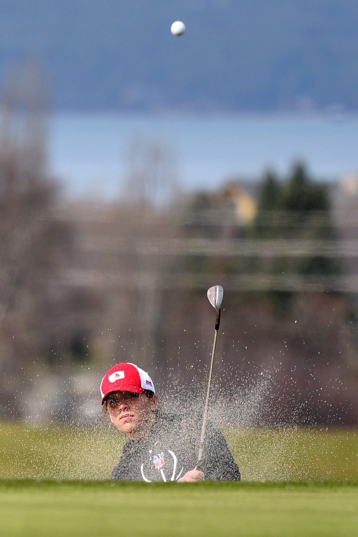 Bigfork&#146;s Isabella Santistevan chips from a greenside bunker on hole No. 2 at Eagle Bend Golf Club in Bigfork on Thursday. (Casey Kreider/Daily Inter Lake)