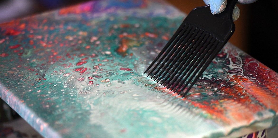 Michael Wear making a flow painting in his home on Monday, April 16, in Kalispell.(Brenda Ahearn/Daily Inter Lake)