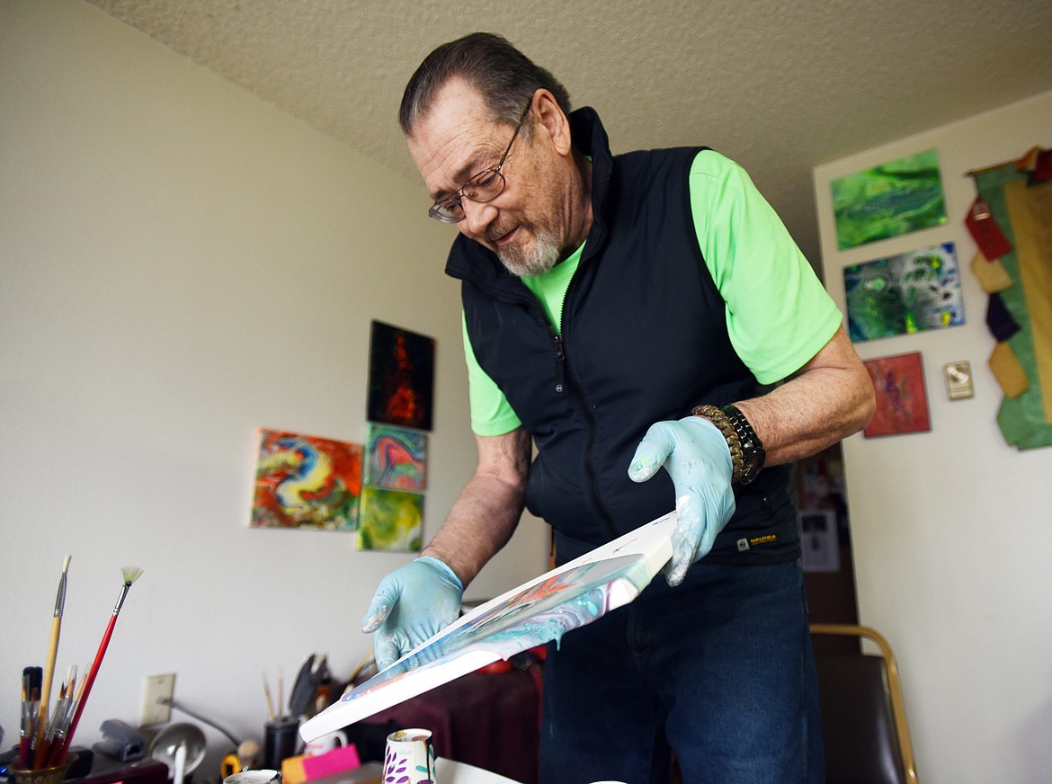 Michael Wear makes a flow painting in his home on Monday, April 16, in Kalispell. (Brenda Ahearn/Daily Inter Lake)