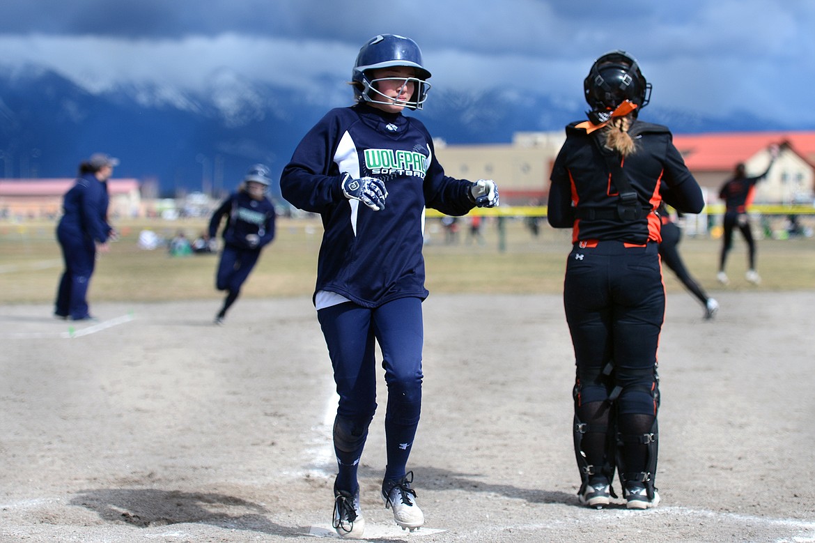 Glacier's Meg Hornby touches home as Addy Labrum rounds third on a 2-run base hit by Alivia Atlee in the bottom of the 4th inning against Flathead on Tuesday. (Casey Kreider/Daily Inter Lake)