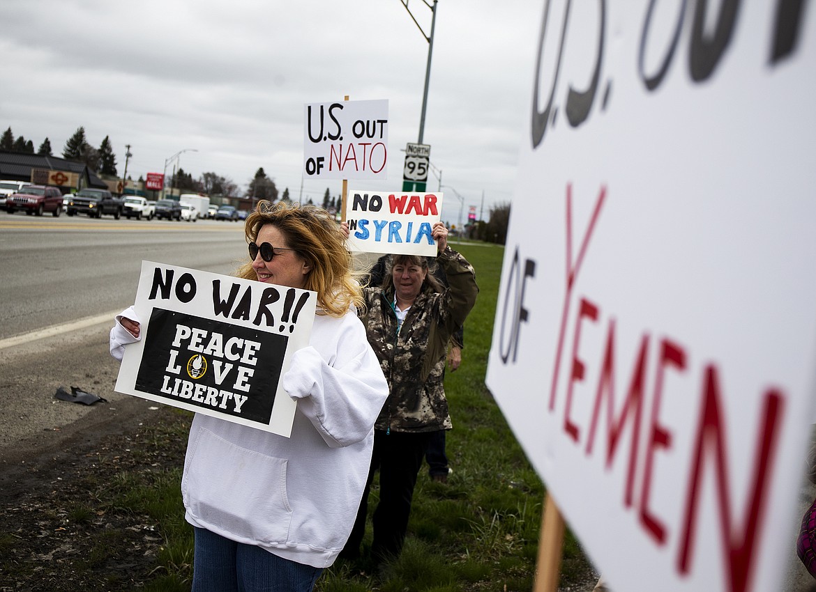 Jennifer Luoma, left, of Bayview, and other North Idaho residents gather at the intersection of Appleway and U.S. 95 to protest the Trump Administration consideration of using military action in response to the alleged use of chemical weapons in Syria on April 7. (LOREN BENOIT/Press)