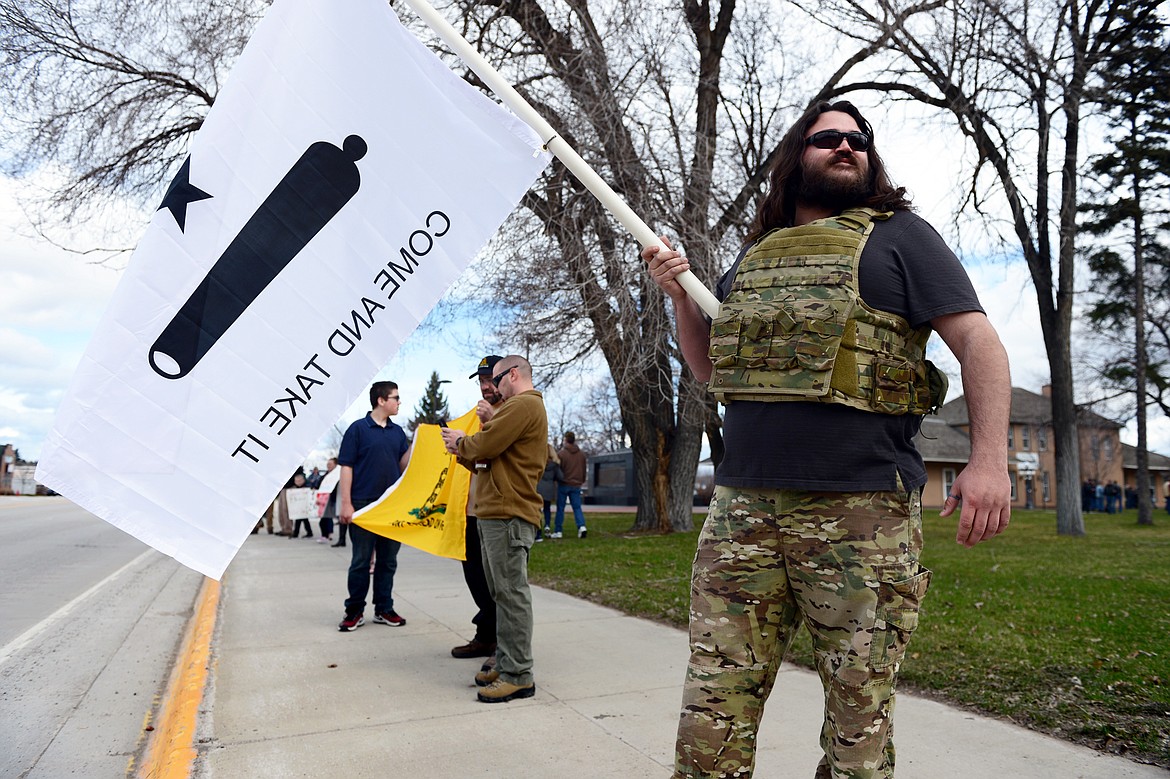 Joshua &#147;Ruby&#148; Ruebenson, of Bigfork, waves a flag along South Main Street in Kalispell before the start of the &#147;Rally for our Rights&#148; pro-gun demonstration in Depot Park on Saturday. (Casey Kreider/Daily Inter Lake)