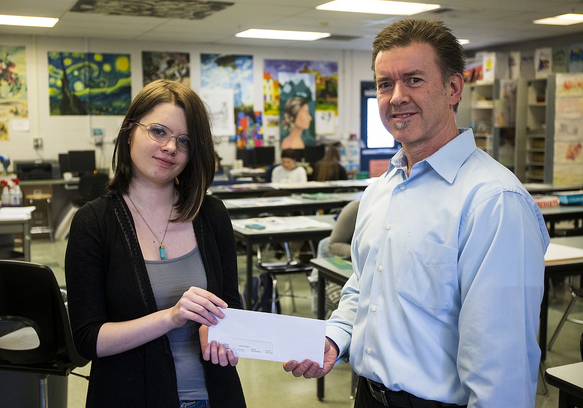 LOREN BENOIT/Press
This year&#146;s design winner is Coeur d&#146;Alene High School sophomore Aliyah Fleshman. The 16-year-old student from Hayden created her design using Prismacolor pencils. Mark A Tucker, executive director with United Way of North Idaho presents Aliyah with a $100 check.
