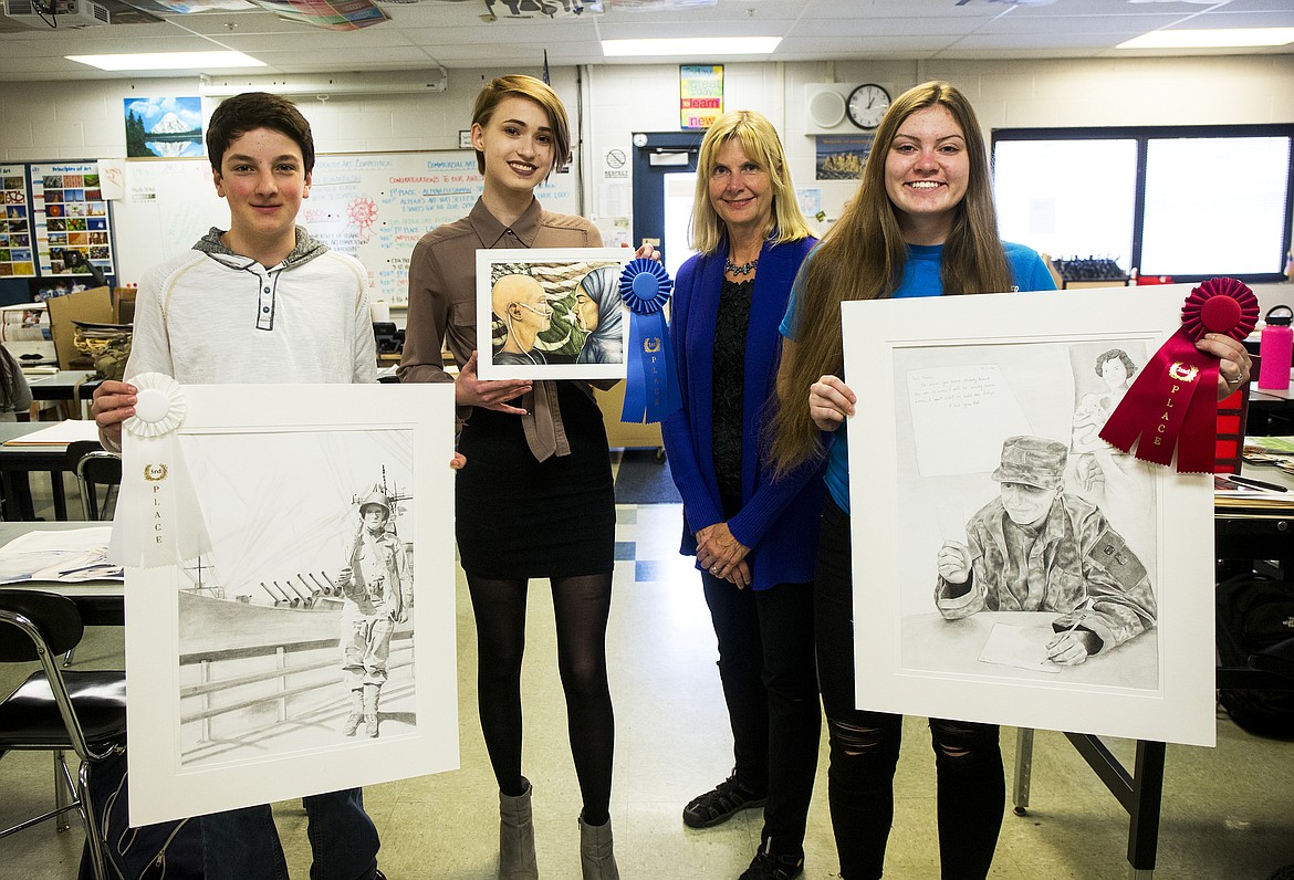 VFW Regional Patriotic Art Competition winners pose with their artwork at Coeur d'Alene High School. From left, 3rd place winner Ethan Skelton, 1st place winner Emily Romanowski, Coeur d'Alene High School art teacher Terri Leonard, and 2nd place winner Gracie Kinsley. Emily Romanowski will head to Boise to compete in state. (LOREN BENOIT/Press)