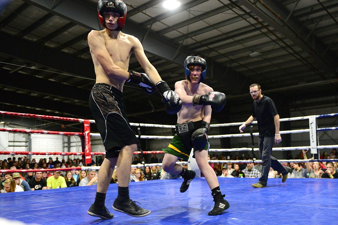 Whitefish High School's Nathan Buckley, right, lands a punch on Flathead High School's Caleb Way at the 9th annual Crosstown Boxing Smoker at the Flathead County Fairgrounds on Thursday night. Buckley won the bout. (Casey Kreider/Daily Inter Lake)