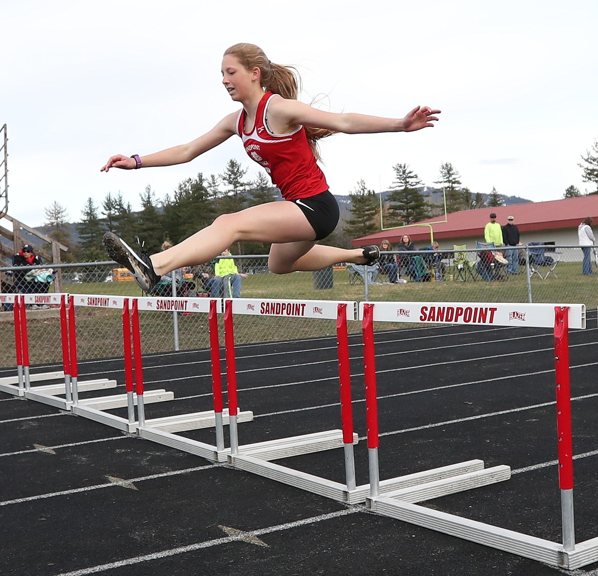 (Photo by ERIC PLUMMER)
Paige Davidson races down the backstretch of the 300 hurdles, as the Bulldogs hosted Lake City, Post Falls and Lakeland in their lone home meet.